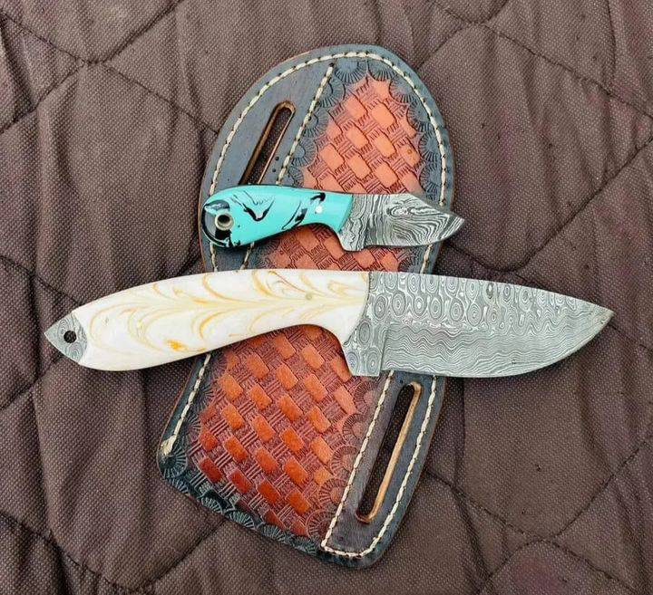 Damascus cowboy bull cutter knife with a resin handle and leather sheath
