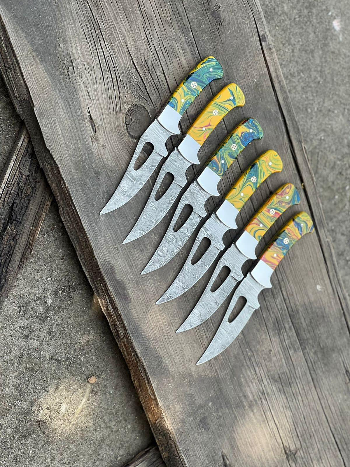 Damascus skinning knife with resin handle, steel bolster, and leather sheath
