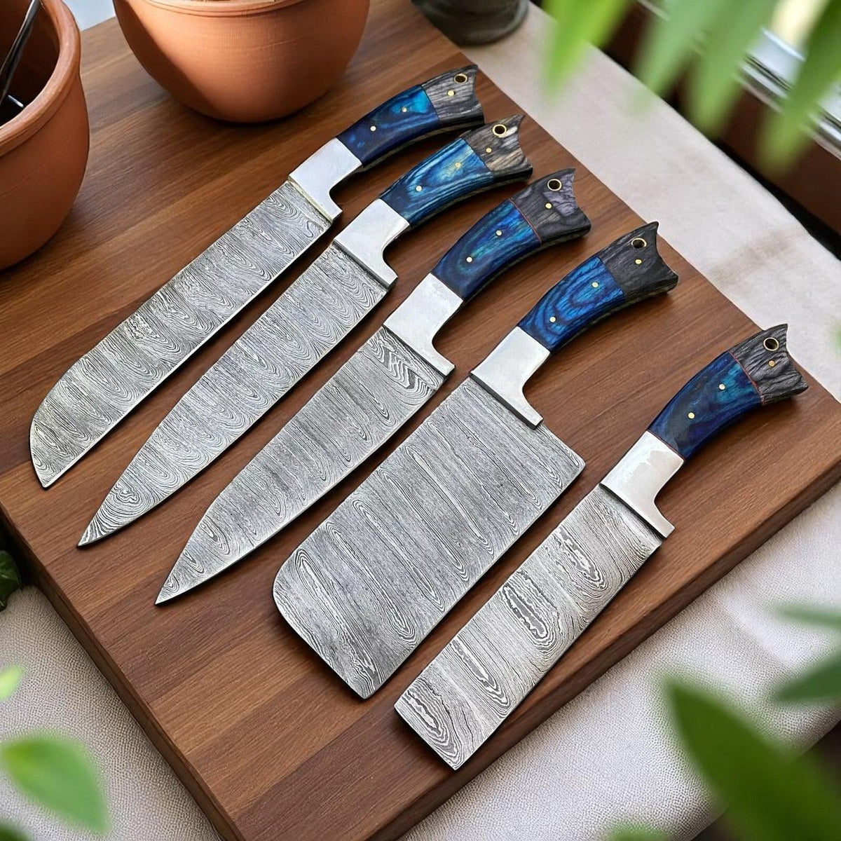Five-piece Damascus chef knife set with blue and gray wood handles