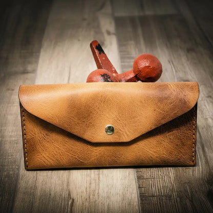 Saddle tan wrap-around leather clutch wallet folded flat, view 2