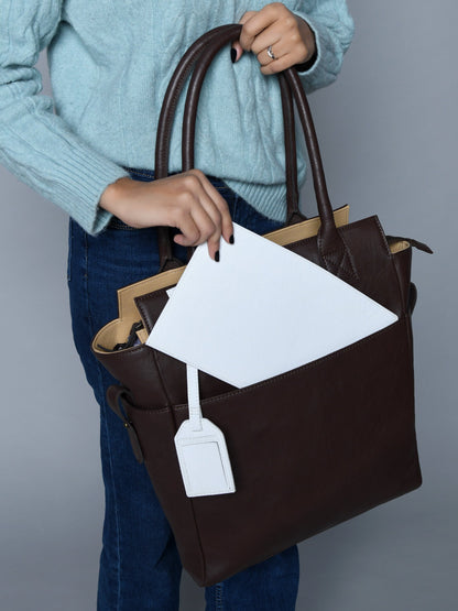 Brown buffalo leather tote with white border trim and hanging tag, view 2