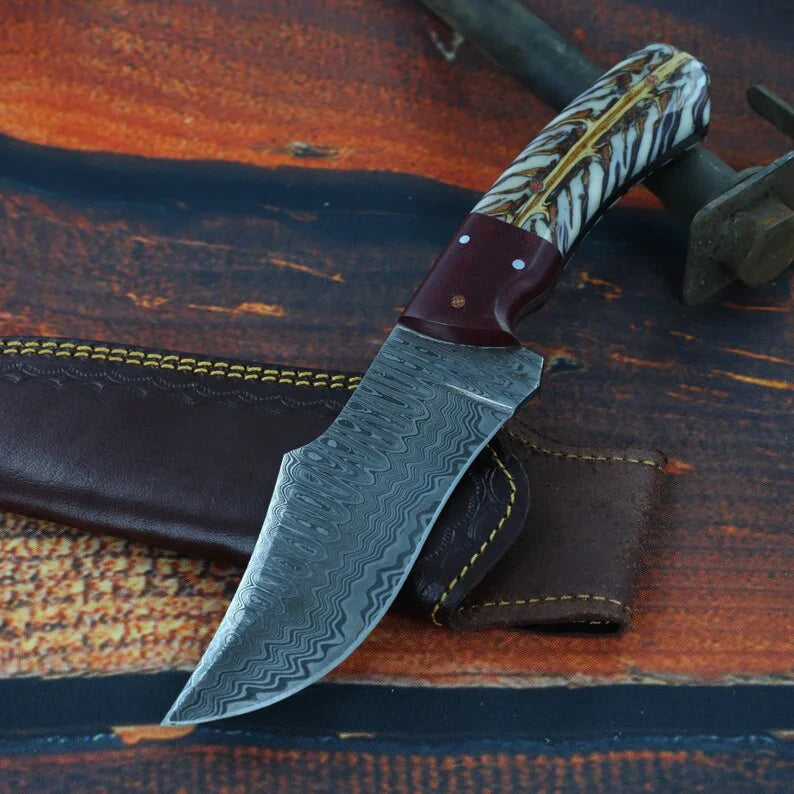 Damascus hunting knife with pine cone resin handle and leather sheath