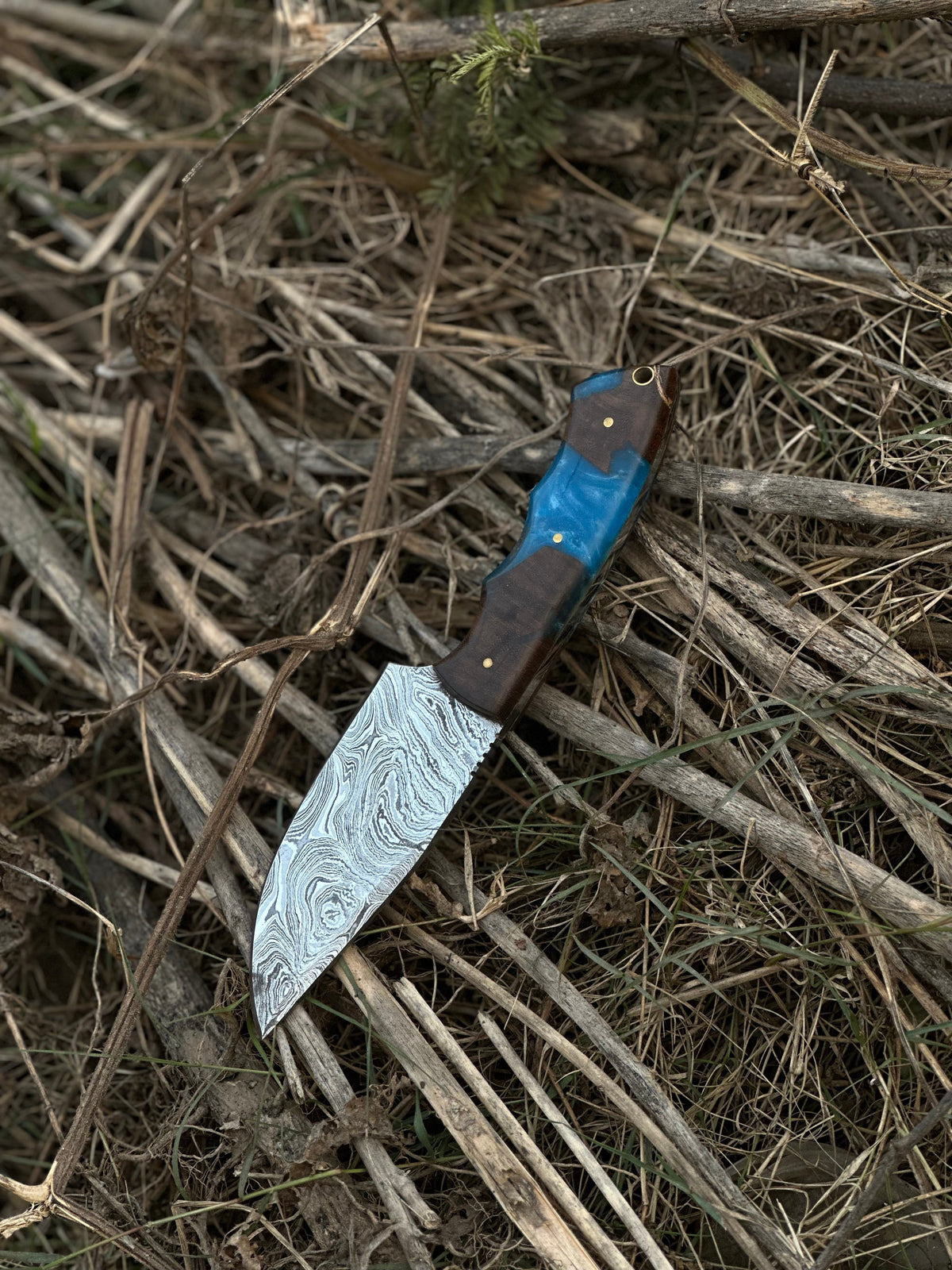 Damascus steel gutting knife with wooden handle and brown leather sheath