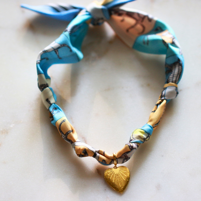 Blue horse print silk scarf necklace with gold charm, view 6