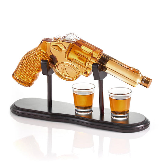 Clear glass pistol-shaped whiskey decanter with a matching shot glass