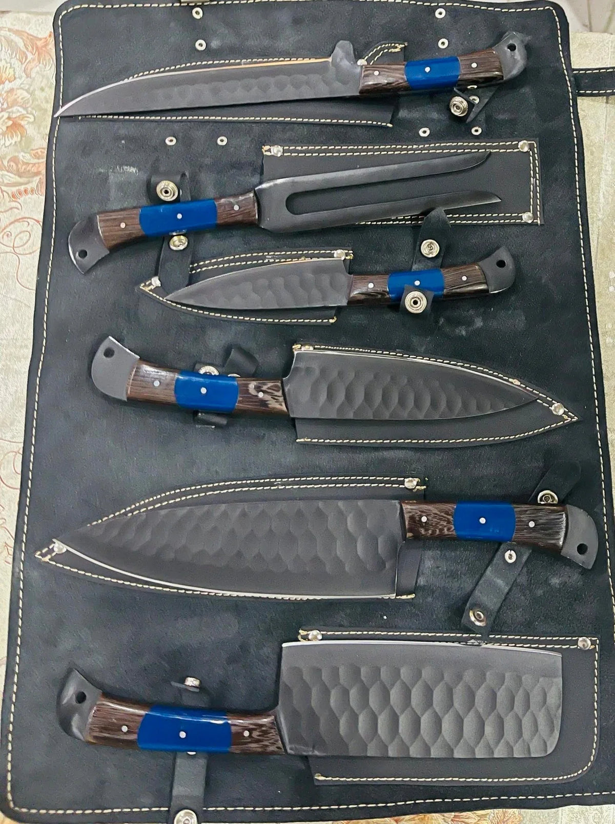 Forged stainless steel chef knife with a dark Wenge wood handle and leather sheath