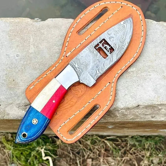 Damascus steel cowboy knife with a red, white and blue USA flag handle and leather sheath