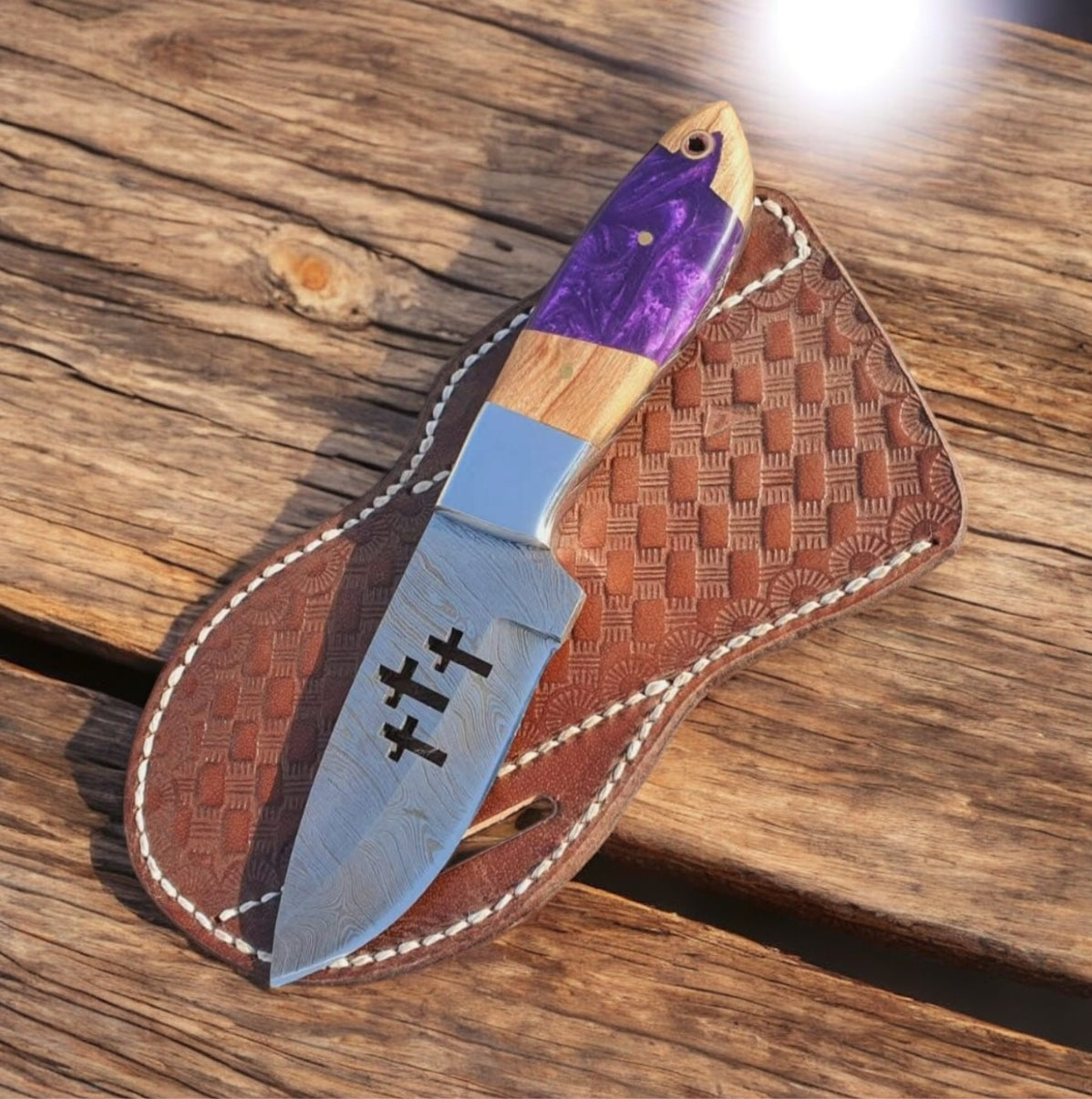 Damascus skinner knife with an olive wood handle, steel bolster and leather sheath