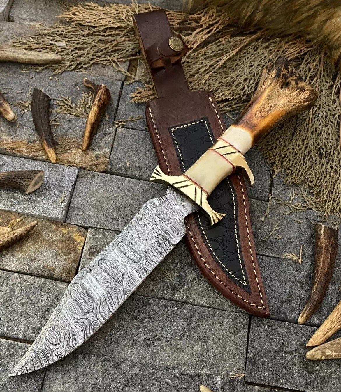 Damascus bowie knife with polished bone handle, brass guard and leather sheath