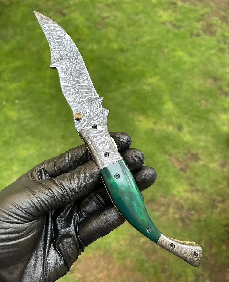Folding Damascus pocket knife with colored bone handle and engraved brass bolster