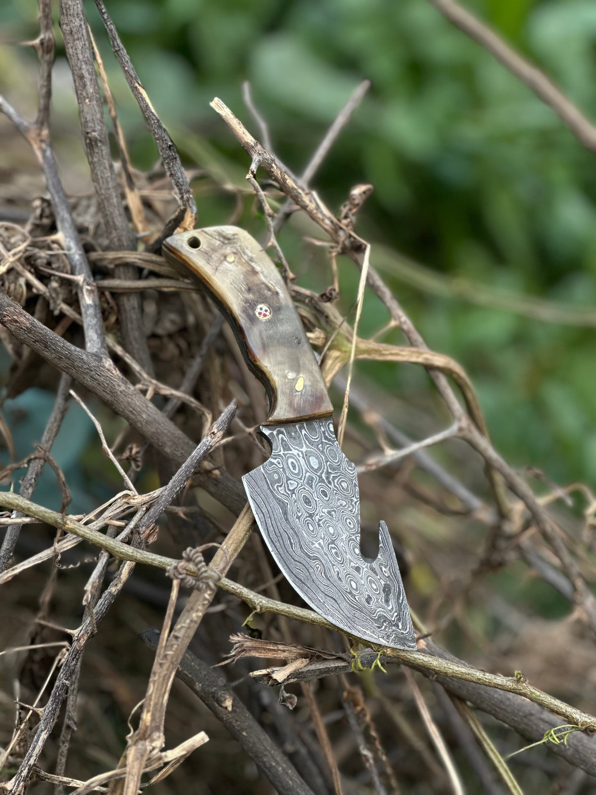 Damascus guthook skinning knife with ridged sheep horn handle and leather sheath