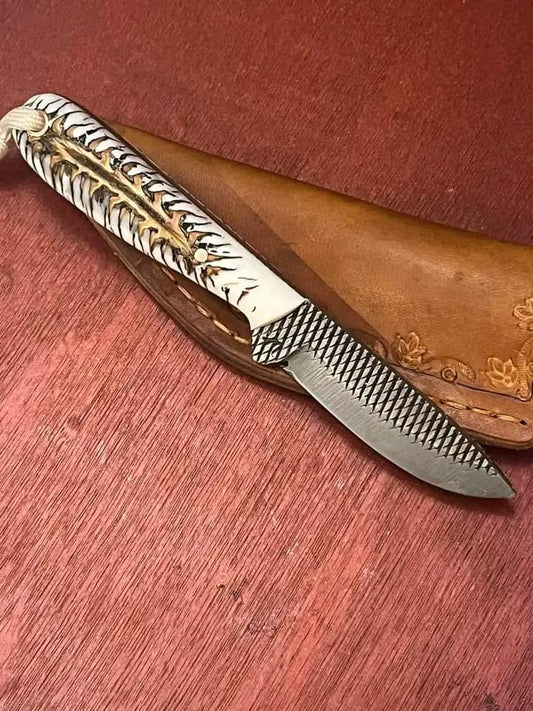 Rasp steel buckaroo belt knife with an epoxy pine cone handle and stitched leather sheath