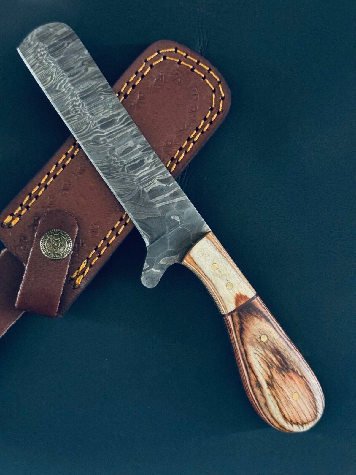 Damascus bull cutter knife with a pakkawood handle and leather sheath