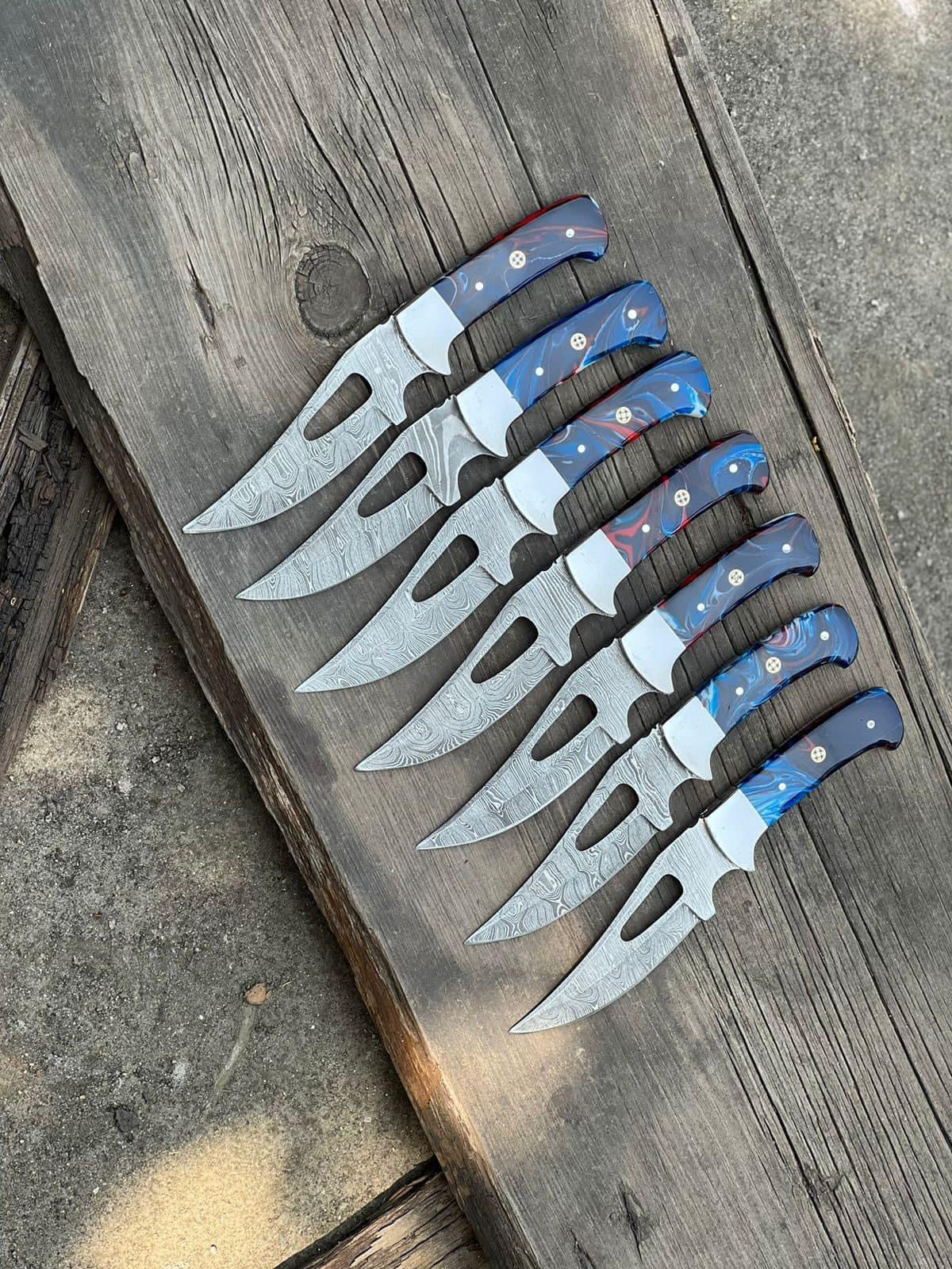 Compact Damascus hunting knife with resin handle and steel bolster