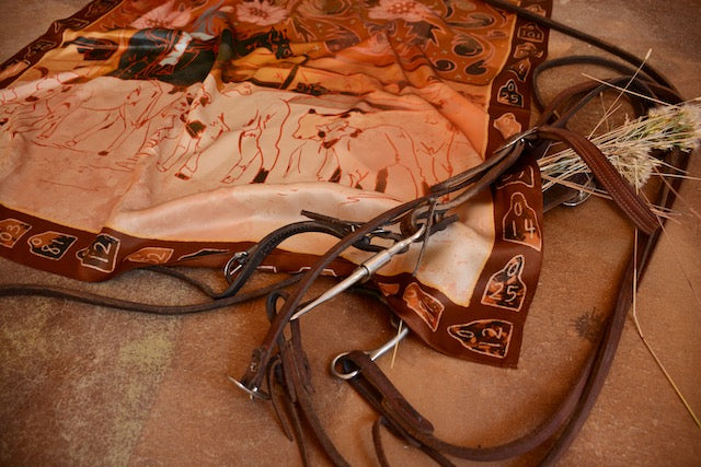 Rust and orange silk wild rag showing a cowgirl roping calves for branding, view 3