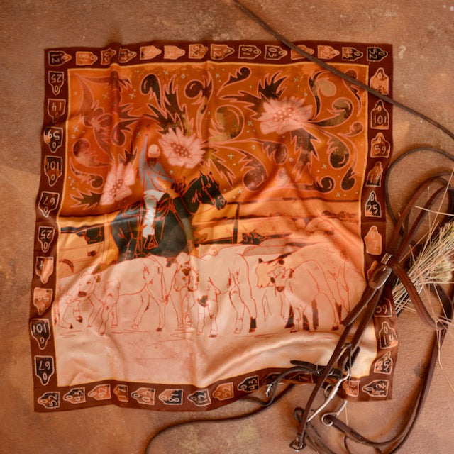 Rust and orange silk wild rag showing a cowgirl roping calves for branding, view 2