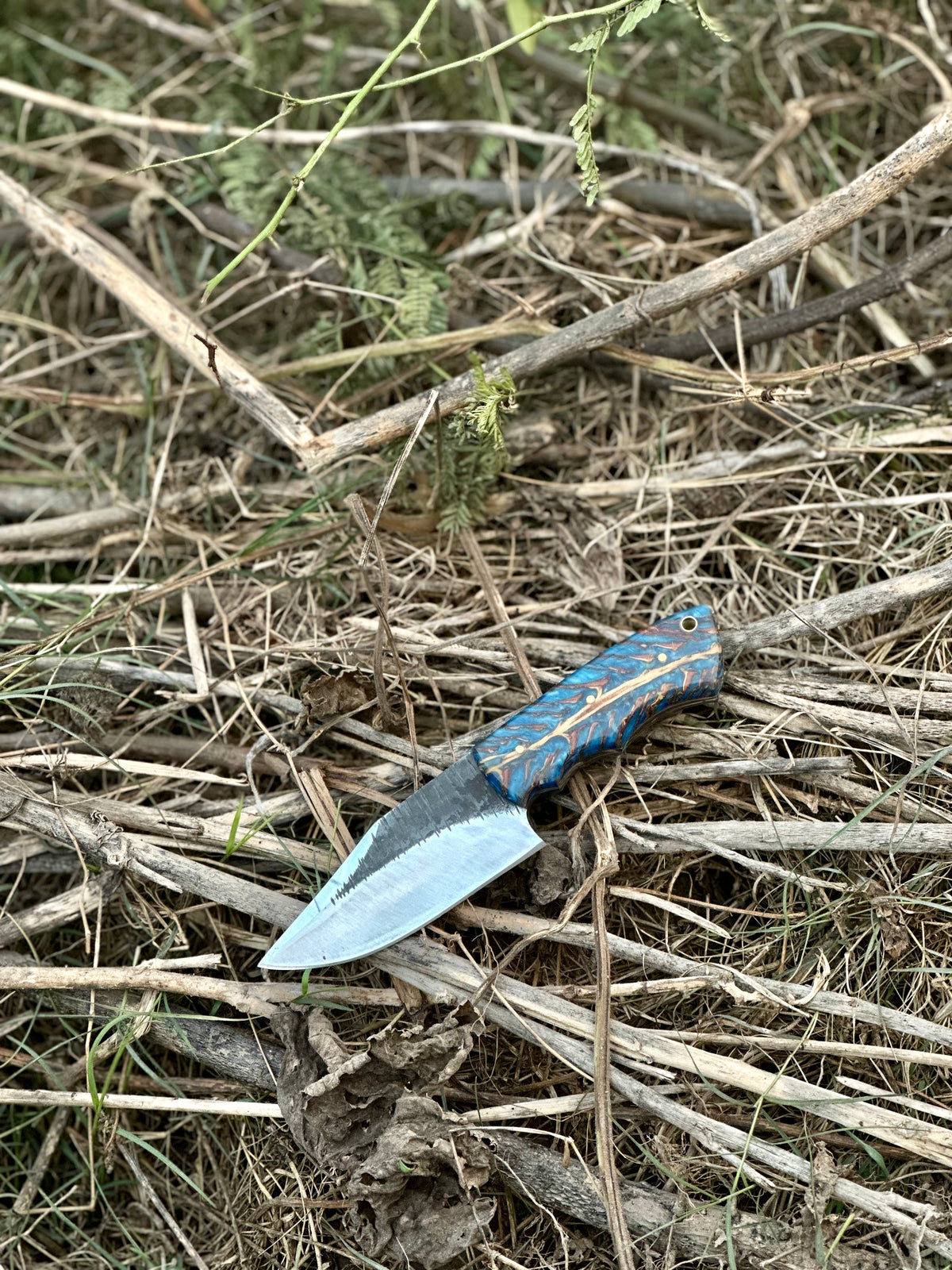 J2 steel hunting knife with colored epoxy resin handle and leather sheath
