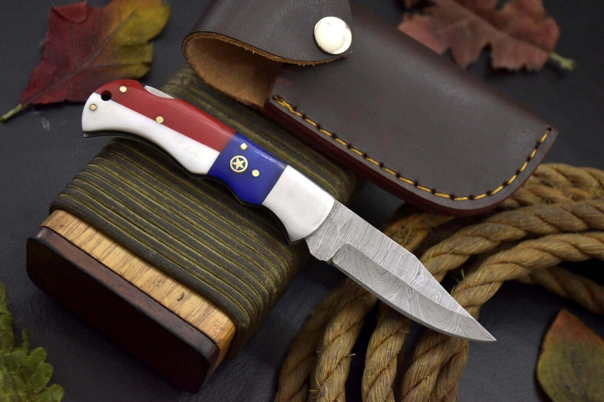 Damascus steel pocket knife with red, white and blue Texas flag handle and leather sheath