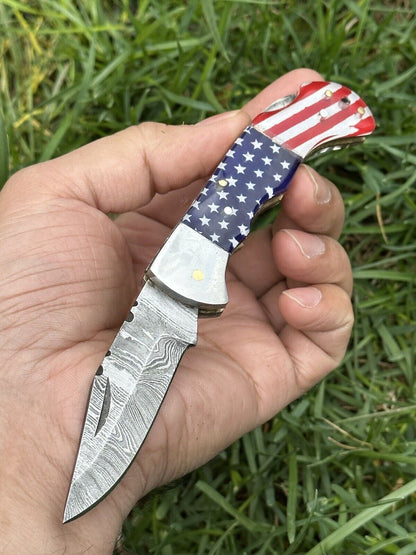 Damascus pocket knife with bone and blue and red Pakka wood handle and steel bolster