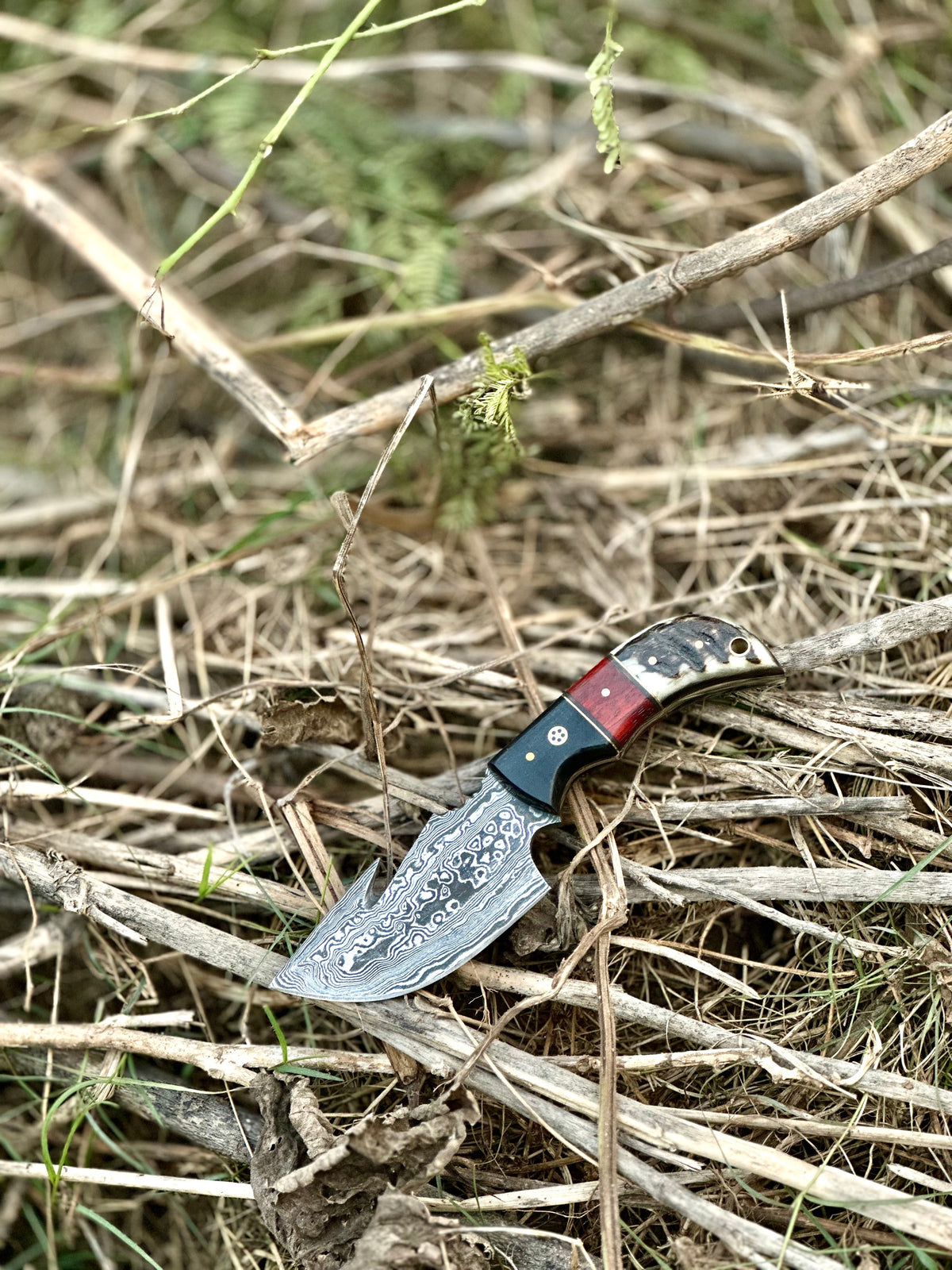 Damascus guthook skinning knife with resin handle and leather sheath