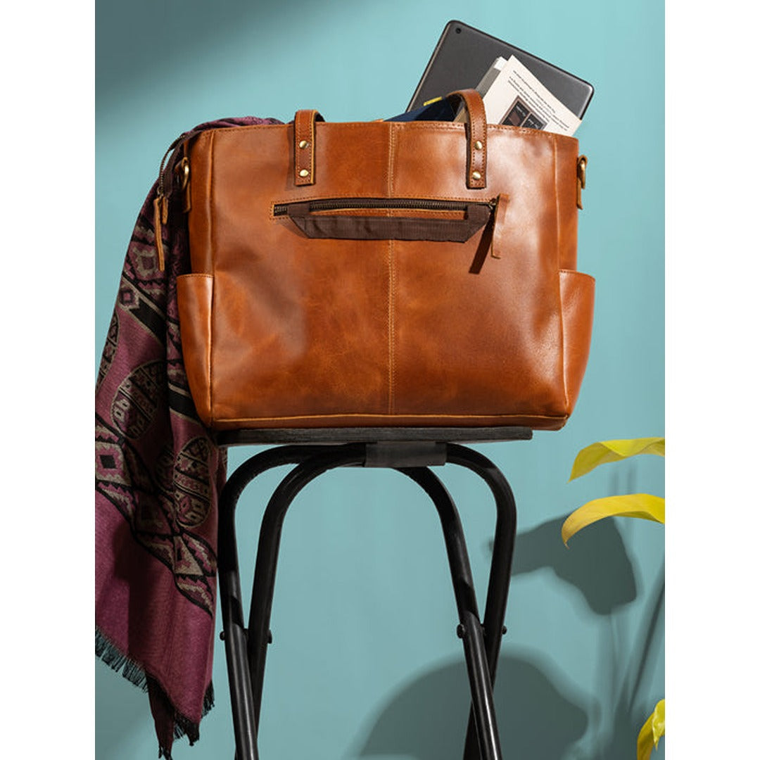 Tan full-grain leather tote bag with top handles and zip pockets, view 4